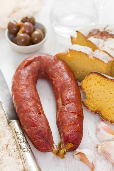 Smoked sausage chorizo with corn bread on wooden background — Stock Photo, Image