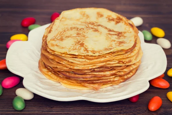 Pancakes on white dish on wooden background — Stock Photo, Image
