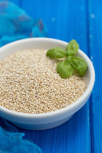 Syrového quinoa v bílé míse na bílém pozadí dřevěná — Stock fotografie