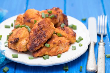 ahşap arka plan üzerinde beyaz plaka üzerinde kızarmış tavuk