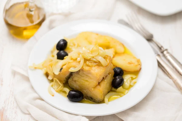 Жареная треска с луком и картофелем на белой тарелке — стоковое фото