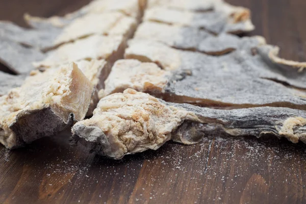 Bacalhau salgado seco sobre fundo de madeira marrom — Fotografia de Stock