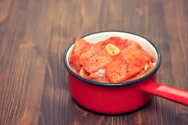 Raw meat with sauce and garlic on pot — Stock Photo, Image