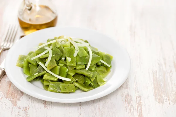 Boiled green beans with onion on white plate — Stock Photo, Image