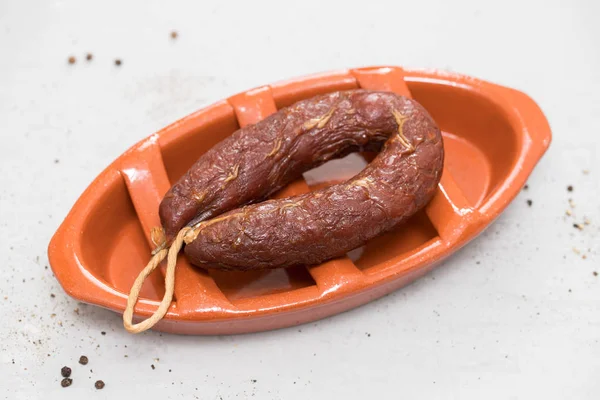 Wędzone kiełbasy chourico na brązowy ceramicznych danie — Zdjęcie stockowe