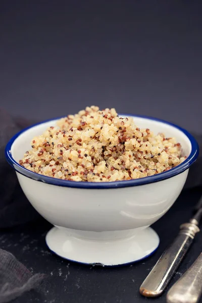 Gekochter Quinoa in weißer Schüssel auf schwarzem Hintergrund — Stockfoto