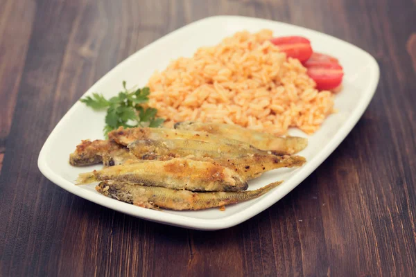 Éperlans frits avec riz tomate sur plat blanc — Photo