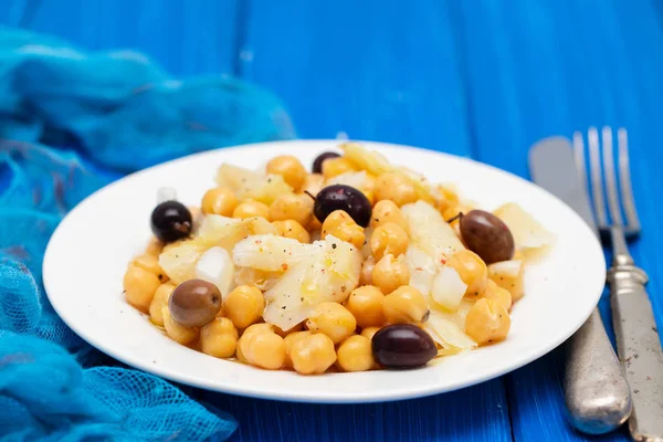 Bacalhau com grão de bico e azeitonas no prato — Fotografia de Stock