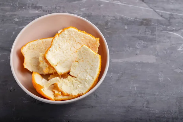 Cáscara de naranja en un tazón pequeño sobre fondo cerámico — Foto de Stock