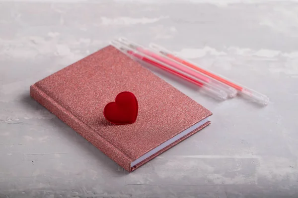 Love heart on notebook with pencils on ceramic background — Stock Photo, Image