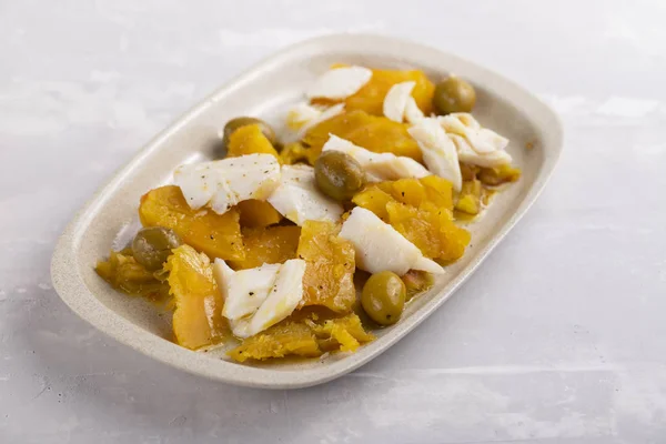 Рыба треска со сладким картофелем и оливки на блюде на керамической бэкгро — стоковое фото