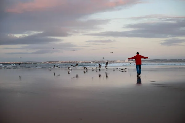 Людина біжить на заході сонця на пляжі океану — стокове фото