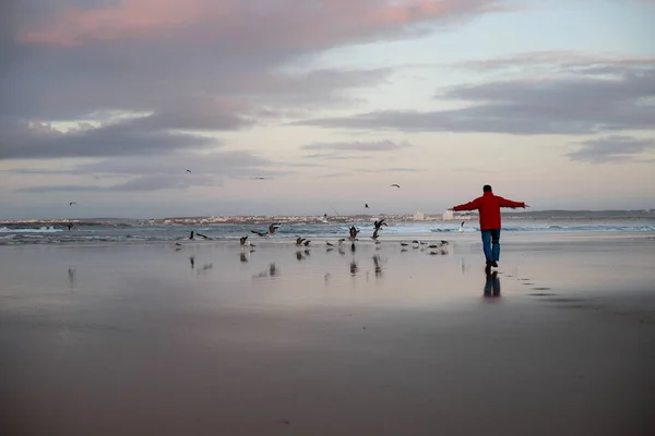 Man running in sunset on beach of ocean — 스톡 사진