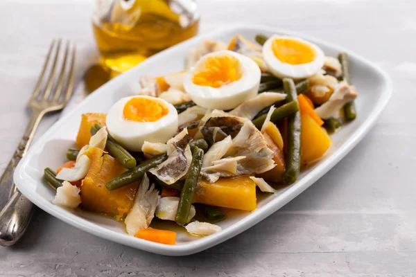 Dorsz ze słodkim ziemniakiem i oliwki na talerzu na ceramicznym backgro — Zdjęcie stockowe