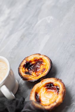 Tipik Portekiz yumurtalı tart pastel de nata ve bir fincan kahve.