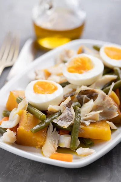 Baccalà con patate dolci e olive su piatto su dorso di ceramica — Foto Stock