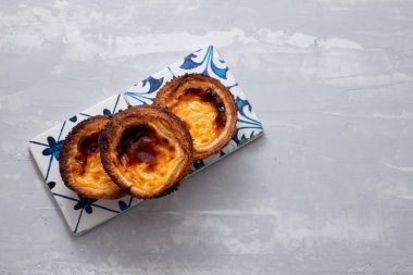 Tipik Portekiz yumurtalı tart pastel de nata ve bir fincan kahve.