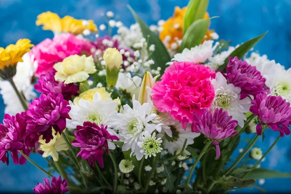 Strauß schöner Blumen mit blauem Hintergrund — Stockfoto