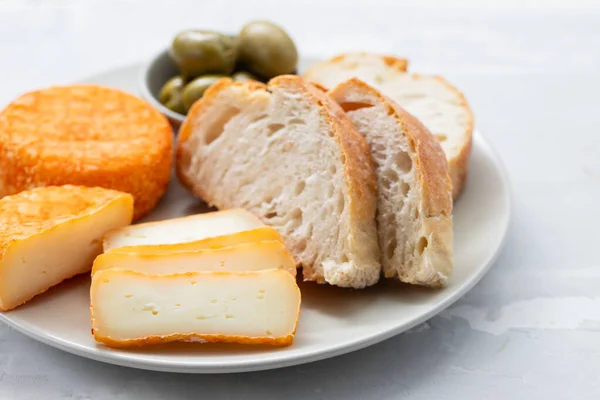 Aperitivo queso con pan y aceitunas en el plato — Foto de Stock