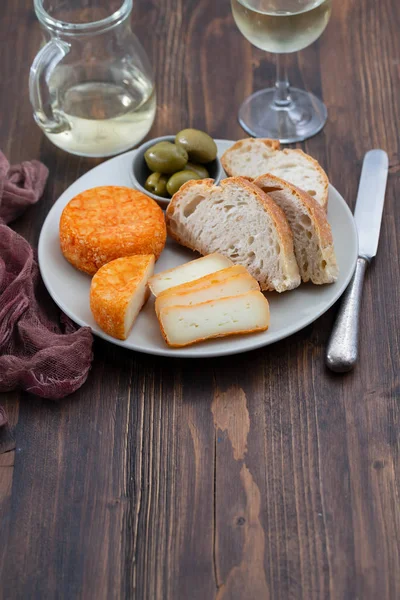 Сыр с хлебом и оливками на блюде — стоковое фото
