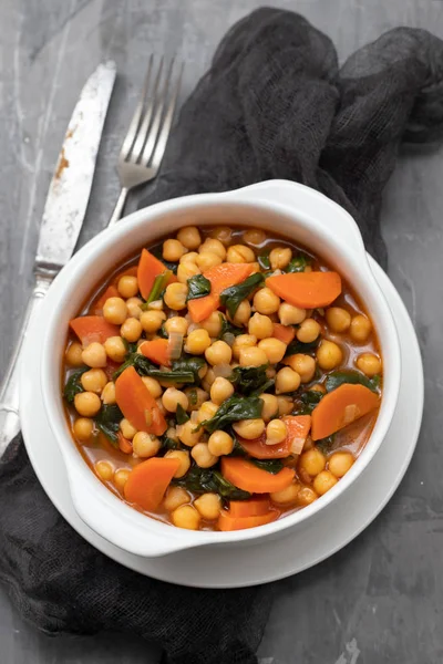 chick-pea with carrot and spinach on white bowl on ceramic backg