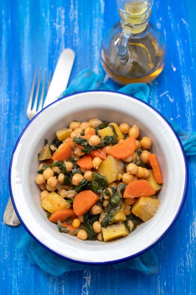 Chick-pea with carrot and spinach on white bowl on blue wooden b — Stock Photo, Image