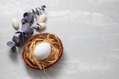 Açık gri seramik arka planda küçük sepetteki yumurta