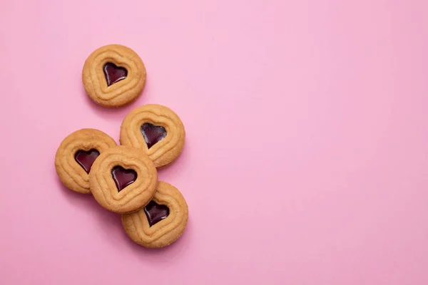 Galletas con corazones sobre fondo rosa — Foto de Stock