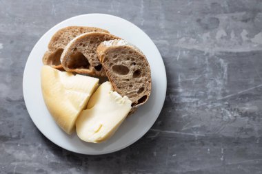 Beyaz tabakta seramik sırtında ekmek olan yumuşak Portekiz peyniri.