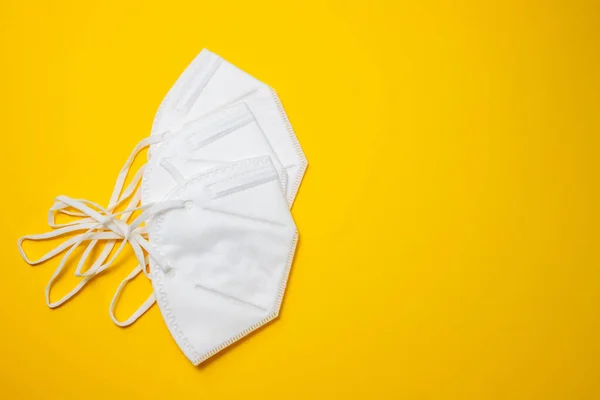 Witte beschermmaskers op gele papieren achtergrond. — Stockfoto