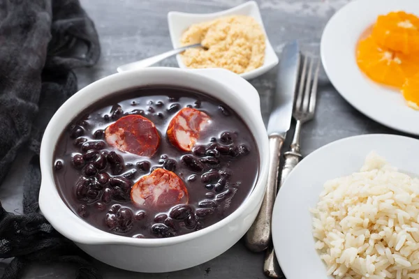 typical brazilian food black beans with smoked sausages in white
