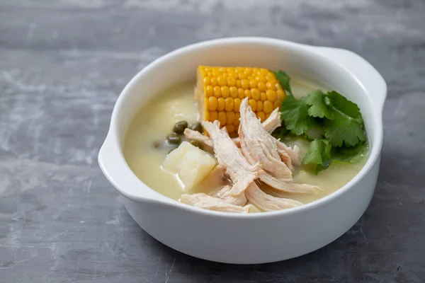 soup potato with corn and chicken in white bowl on ceramic background
