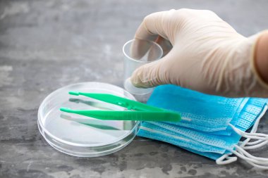 tıbbi maske, plastik bardaklar ve seramik arkaplanda diğer tıbbi nesneler