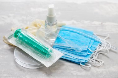 tıbbi maske, plastik bardaklar ve seramik arkaplanda diğer tıbbi nesneler