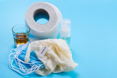yüz maskesi, eldivenler, cam ve tuvalet kağıdı mavi arka planda