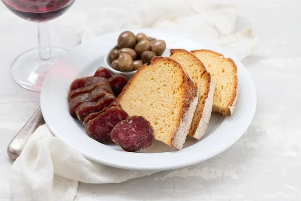 Maisbrot Mit Räucherwurst Und Oliven Auf Weißem Teller — Stockfoto