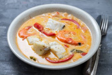 karidesli balık ve soslu biber seramik arka planda.