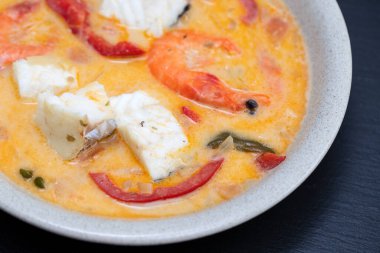 karidesli balık ve soslu biber seramik arka planda.