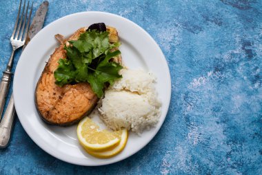 Kızarmış somon salatası, limon ve kaynamış pirinç.