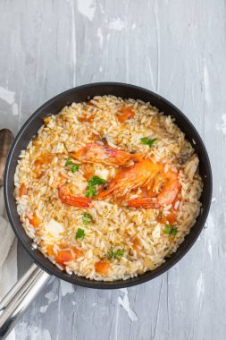 seramik arka planda balık ve deniz mahsullü pilav.