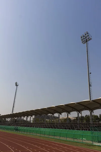 Poste de luz del punto en un estadio contra cielo azul ; — Foto de Stock