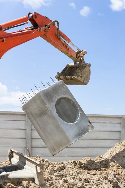 Excavadora levantar una alcantarilla — Foto de Stock