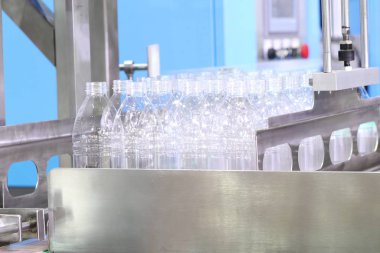Üretim sırasında bir grup plastik şişe suyu doldurmak için bekliyor. 