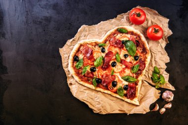 Kalp pizza domates ve mozzarella ile Sevgililer günü için vintage siyah arka plan üzerine şeklinde. Romantik aşk kavramını gıda
