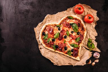 Kalp pizza domates ve mozzarella ile Sevgililer günü için vintage siyah arka plan üzerine şeklinde. Romantik aşk kavramını gıda