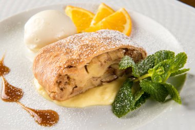 Dondurma ve turuncu beyaz plaka üzerinde Apple strudel