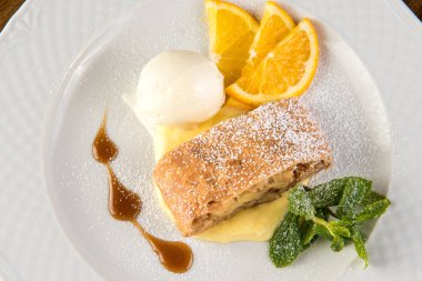 Dondurma ve turuncu beyaz plaka üzerinde Apple strudel