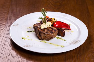 Biberiye ve kızarmış sebze peynir beyaz plaka üzerinde kalın biftek