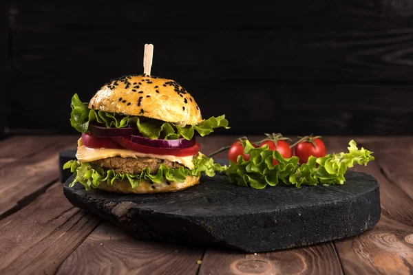 Double Burger on the board on beautiful black wooden rustic background