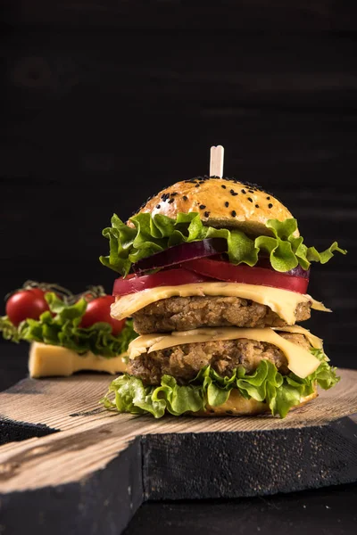 Doppelburger auf dem Brett auf schönem schwarzem Holz rustikalem Hintergrund — Stockfoto